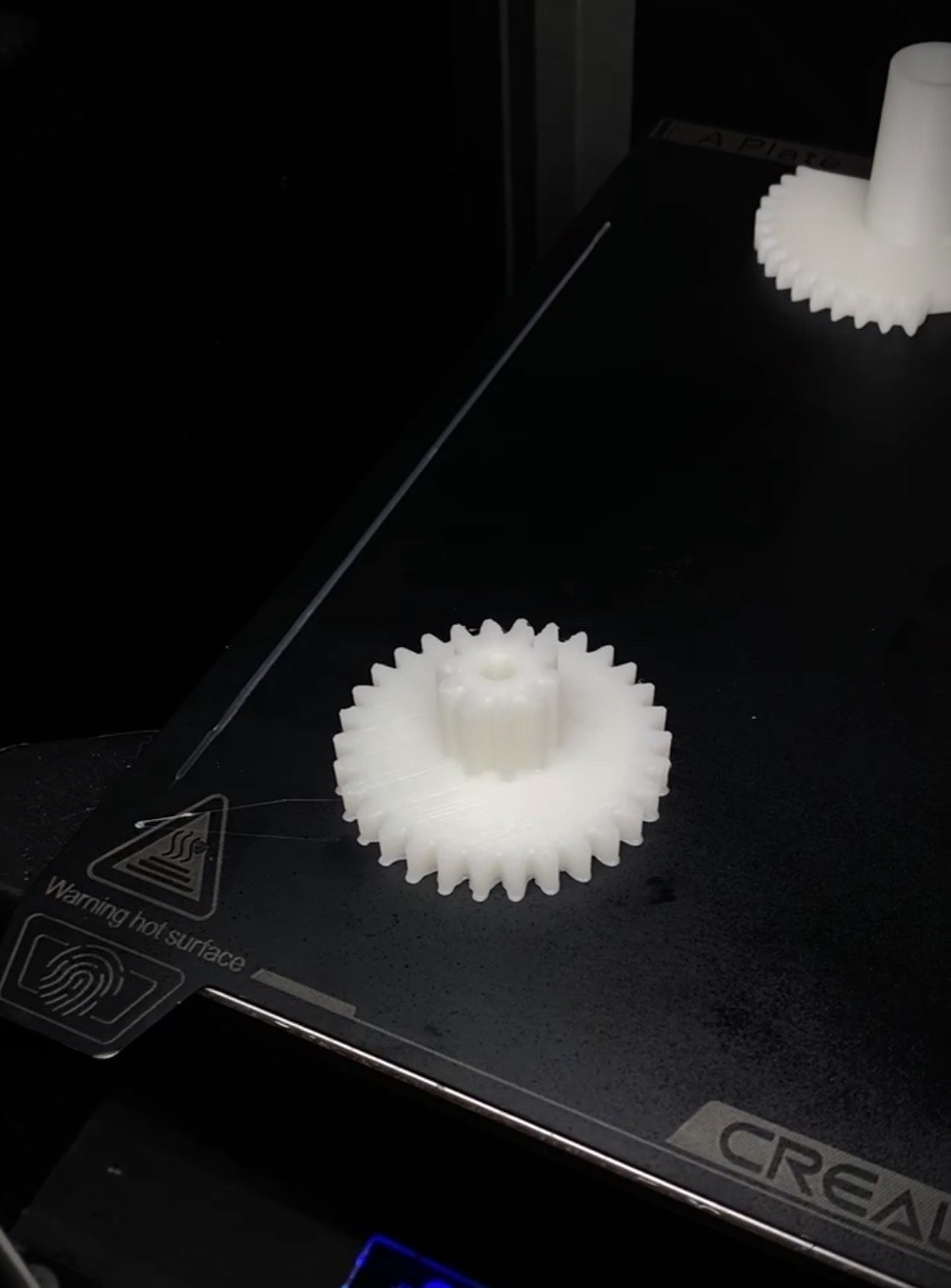 Engrenages neufs imprimés en 3D sur le plateau de l'imprimante
